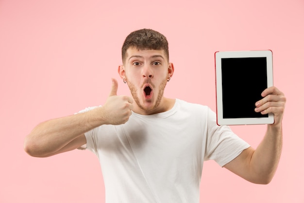 Retrato de um homem sorridente apontando para um laptop com uma tela em branco isolada no branco