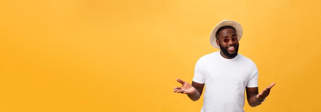 Retrato de um jovem africano bonito sorrindo em camiseta branca sobre fundo amarelo