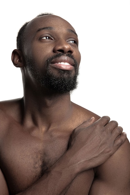 Retrato de um jovem africano nu feliz e sorridente no estúdio.