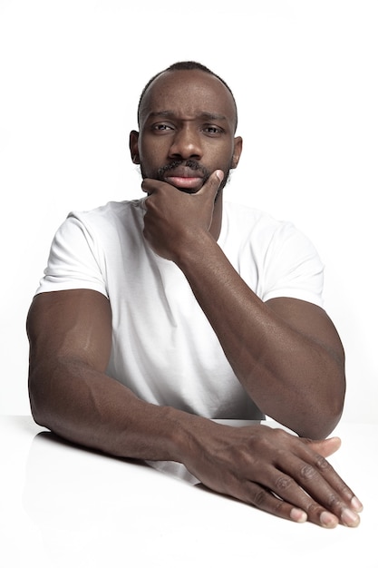 Retrato de um jovem africano sério no estúdio. modelo masculino de alta costura posando e isolado no fundo branco