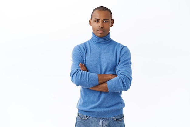 Retrato de um jovem afro-americano determinado, com cerdas cruzadas, mãos sobre o peito, parecendo confiante e pronto para a ação, iniciando o próprio negócio stand fundo branco