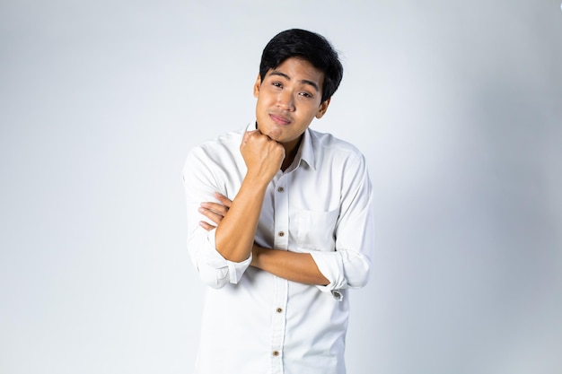 Retrato de um jovem asiático animado e feliz, de braços cruzados e sorrindo sobre um fundo cinza
