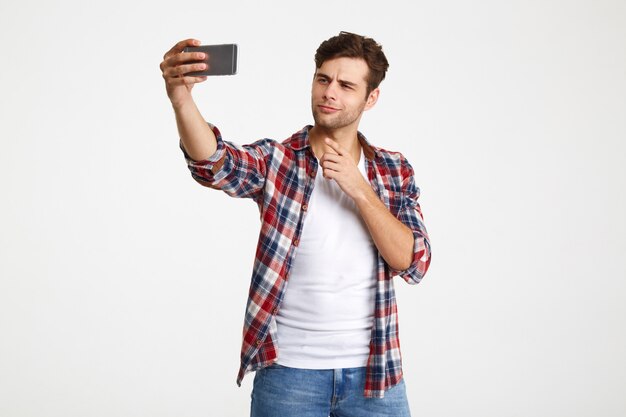 Retrato de um jovem atraente, tomando uma selfie