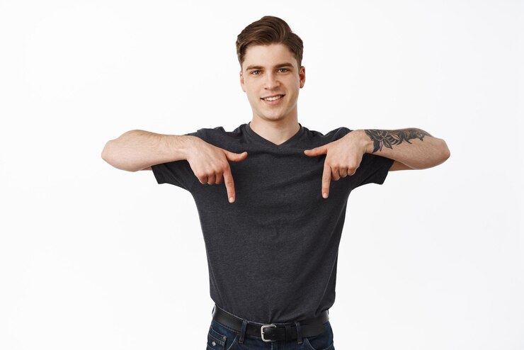 Foto grátis retrato de um jovem bonito e moderno aponta para baixo mostra o anúncio abaixo sorrindo feliz demonstra o fundo branco do produto