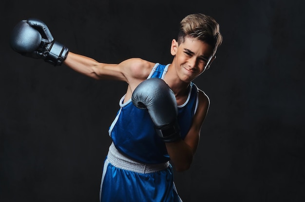 Retrato de um jovem boxeador bonito durante exercícios de boxe, focado no processo com facial concentrado sério.