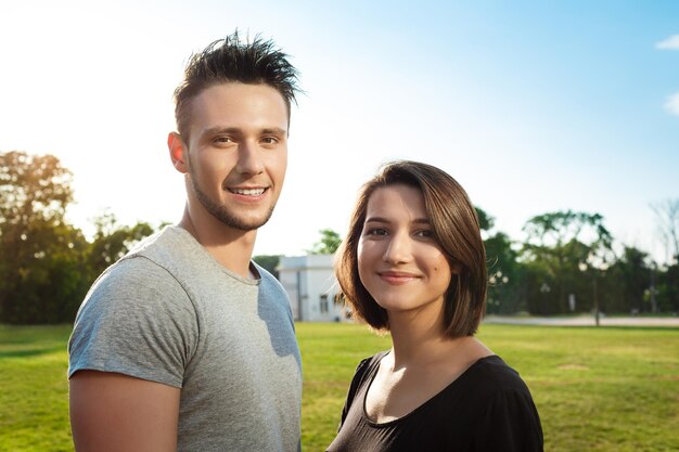 Retrato de um jovem casal lindo sorrindo relaxante no parque.