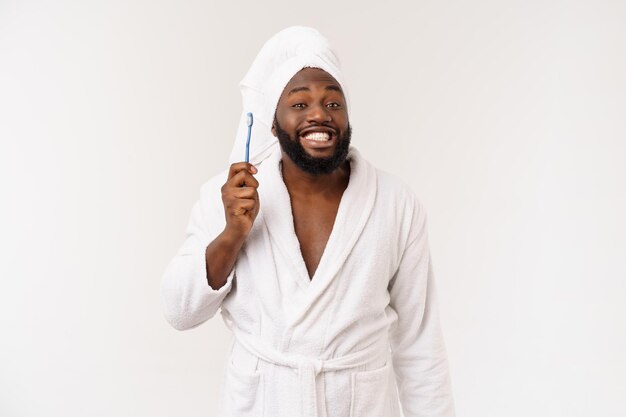 Retrato de um jovem darkanm feliz escovando os dentes com pasta de dente preta sobre fundo branco