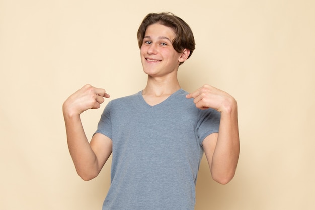 Retrato de um jovem do sexo masculino com camiseta cinza posando sorrindo