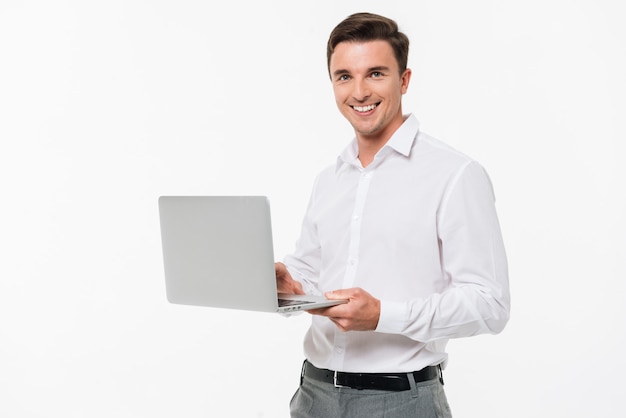 Retrato de um jovem feliz, segurando o computador portátil