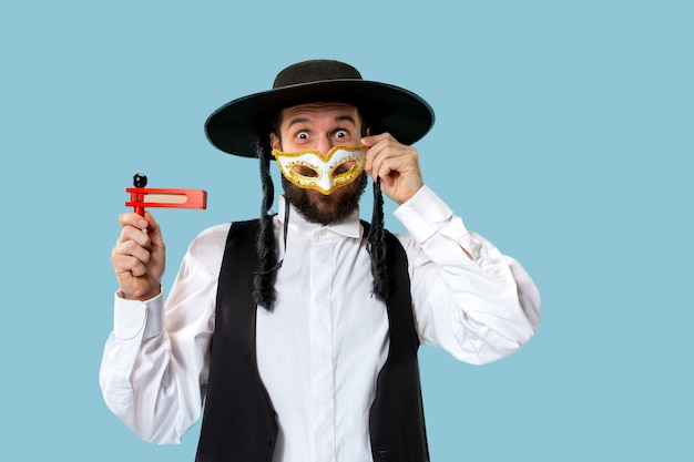 Retrato de um jovem judeu ortodoxo com catraca de madeira durante o festival de purim