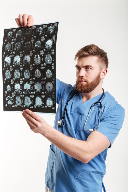 Retrato de um jovem médico analisando uma tomografia computadorizada