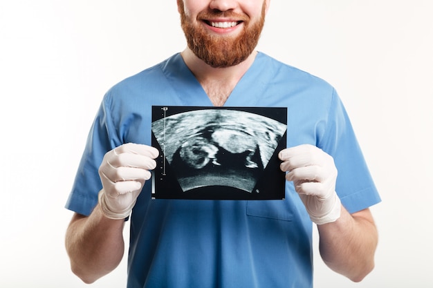 Foto grátis retrato de um jovem médico masculino sorridente, mostrando radiografia