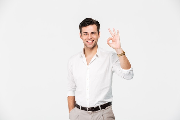 Retrato de um jovem sorridente na camisa mostrando ok