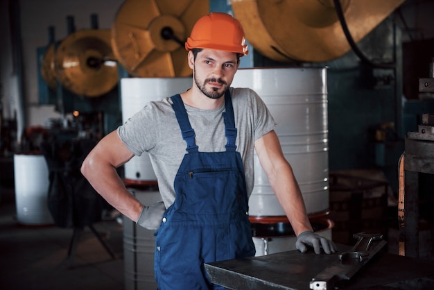 Retrato de um jovem trabalhador em um capacete em uma grande fábrica de reciclagem de resíduos.