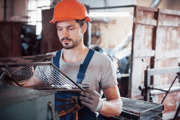 Retrato de um jovem trabalhador em um capacete em uma grande fábrica de reciclagem de resíduos.