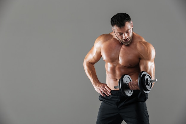 Retrato de um levantamento de fisiculturista masculino sem camisa forte sério