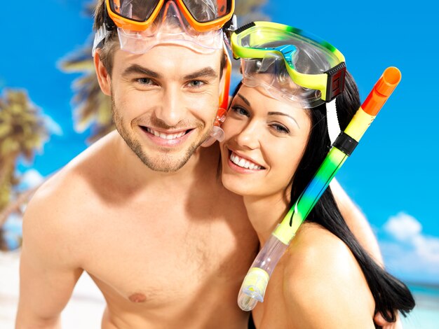 Retrato de um lindo casal feliz e divertido em uma praia tropical com máscara de natação no rosto