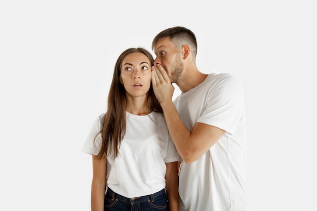 Foto grátis retrato de um lindo casal jovem isolado na parede branca do estúdio