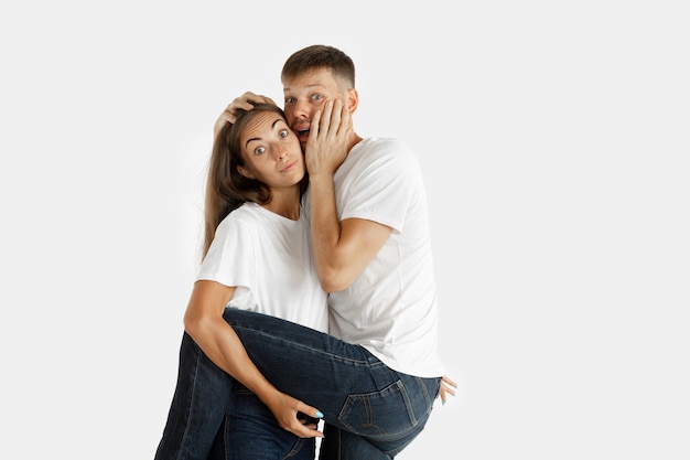 Foto grátis retrato de um lindo casal jovem isolado na parede branca do estúdio