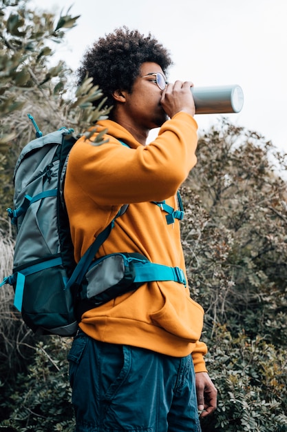 Retrato, de, um, macho, hiker, com, seu, mochila, bebendo, a, água, de, garrafa