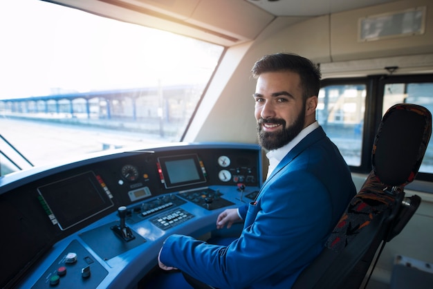 Retrato de um maquinista sentado no banco do motorista de um trem de metrô para transporte público