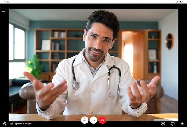 Foto grátis retrato de um médico em uma videochamada para uma consulta virtual com um paciente