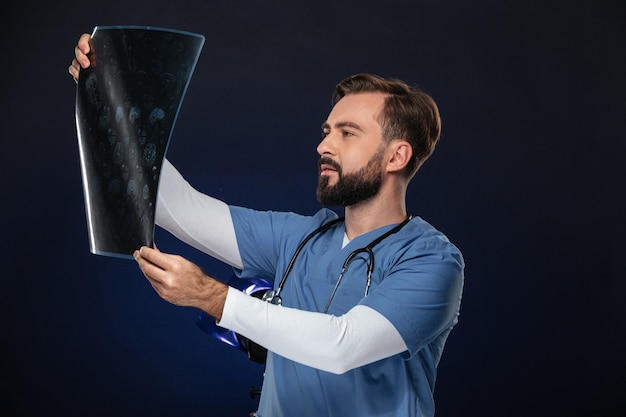 Retrato de um médico homem concentrado, vestido de uniforme