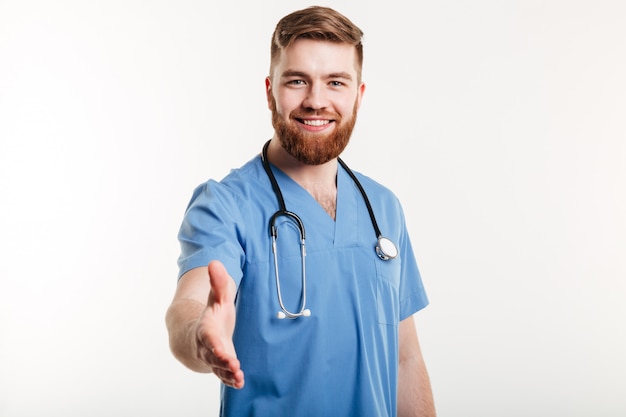 Retrato de um médico sorridente amigável, esticando a mão para um aperto de mão