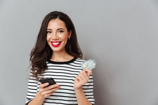 Retrato, de, um, menina feliz, segurando telefone móvel