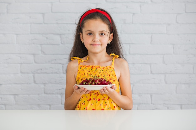 Foto grátis retrato, de, um, menina, segurando, prato, de, cerejas vermelhas