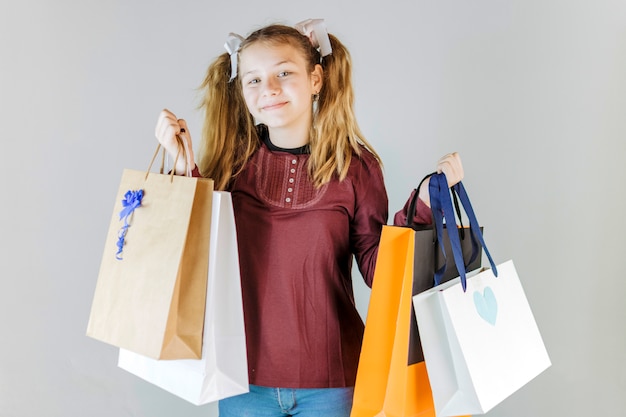 Foto grátis retrato, de, um, menina sorridente, segurando, bolsas para compras