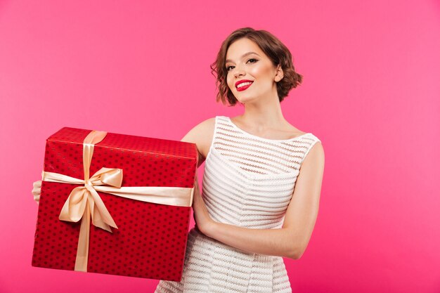 Retrato, de, um, menina sorridente, vestido vestido, segurando caixa presente