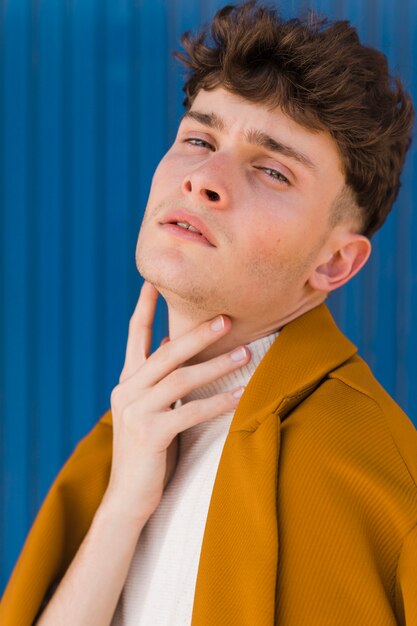Retrato de um menino elegante contra uma parede azul