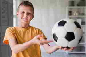 Foto grátis retrato, de, um, menino sorridente, mostrando, bola futebol