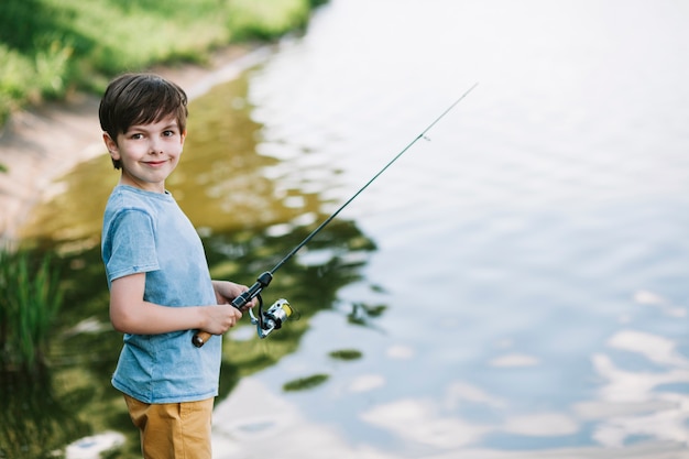 Retrato, de, um, menino sorridente, pesca, ligado, lago