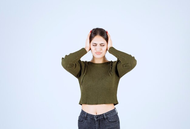 Retrato de um modelo de mulher jovem e bonita em pé e segurando a cabeça dela.