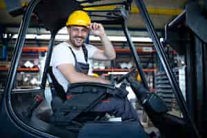 Foto grátis retrato de um motorista de empilhadeira profissional sorridente no armazém da fábrica