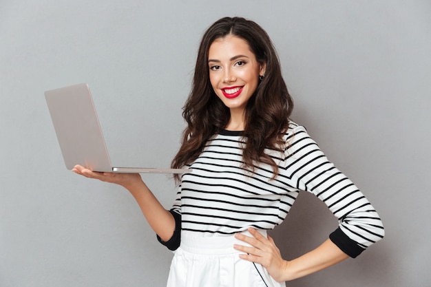 Retrato, de, um, mulher confiante, segurando computador portátil