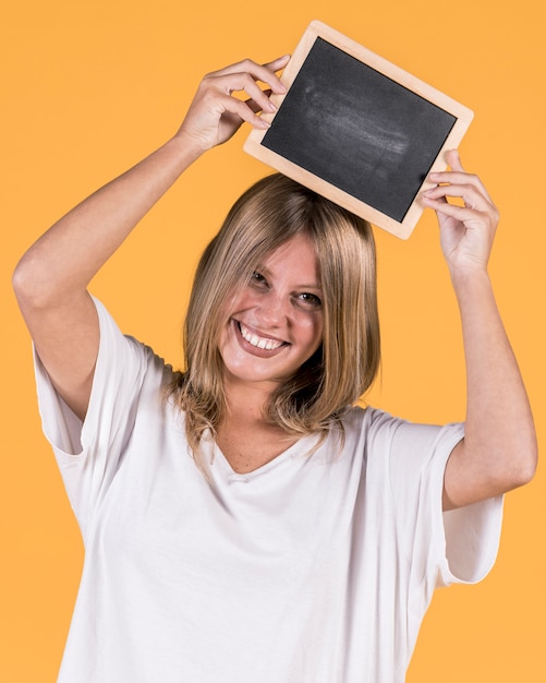 Retrato, de, um, mulher feliz, segurando, em branco, ardósia, sobre, dela, cabeça