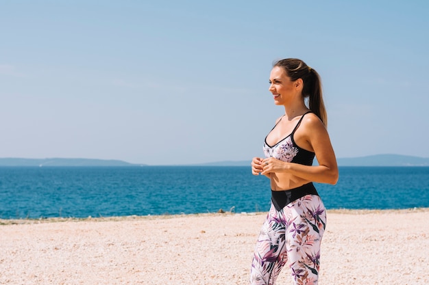 Foto grátis retrato, de, um, mulher jovem, em, desgaste aptidão, ficar, perto, a, praia