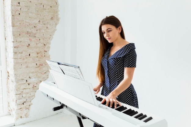 Retrato, de, um, mulher jovem, olhar, musical, folha, tocando piano