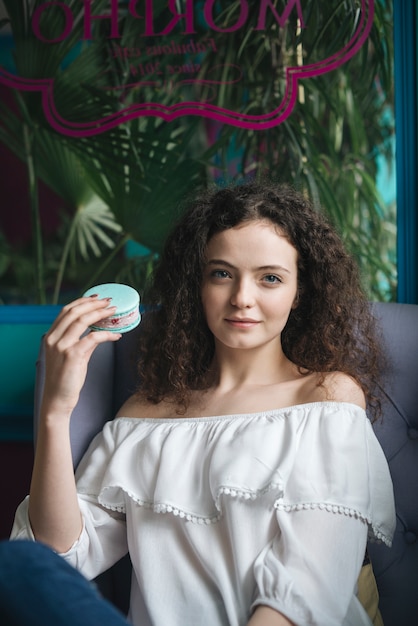 Foto grátis retrato, de, um, mulher jovem, sentando, em, a, café, segurando, sorvete, sanduíche