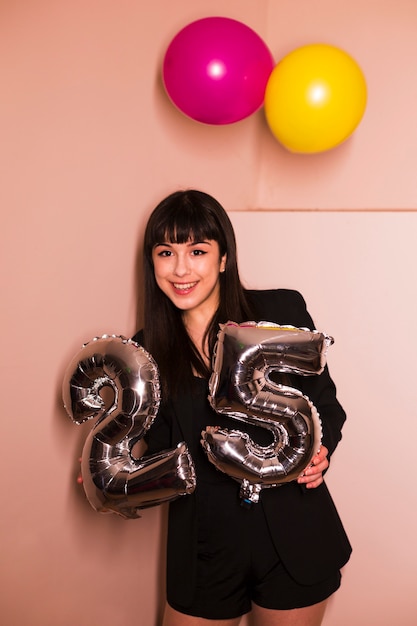 Foto grátis retrato, de, um, mulher sorridente, segurando, 25, celebração prata, balloon, em, mão