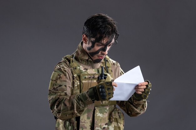 Retrato de um soldado camuflado segurando uma carta