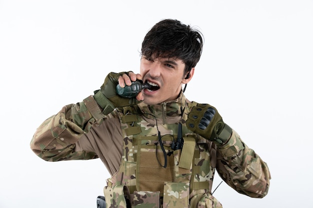 Retrato de um soldado lutando durante a operação com uma parede branca de granada