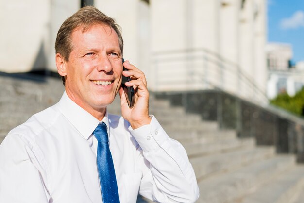 Retrato, de, um, sorrindo, maduras, homem negócios, falando telefone móvel