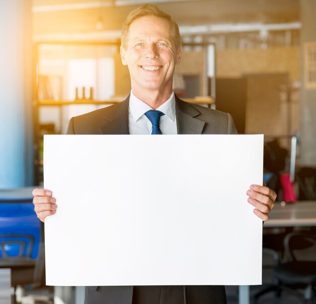 Retrato, de, um, sorrindo, maduras, homem negócios, segurando, em branco, painél public