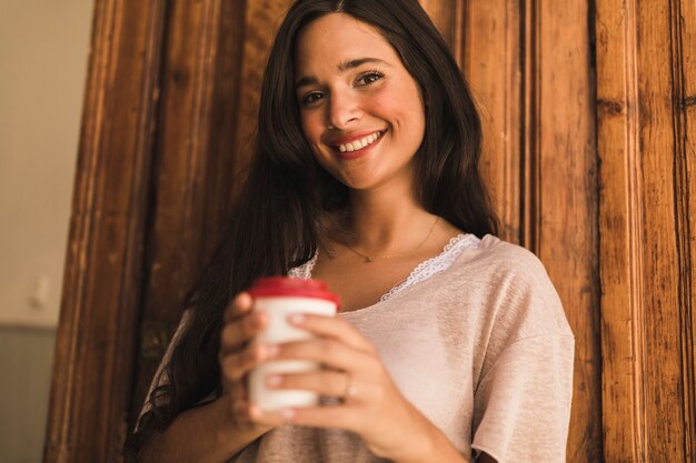 Retrato, de, um, sorrindo, menina adolescente, segurando, copo café descartável