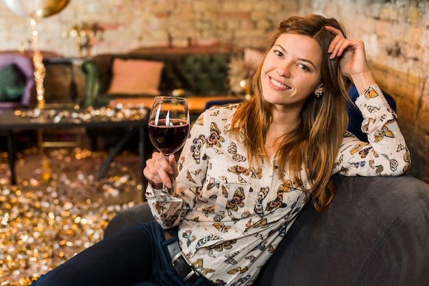 Foto grátis retrato, de, um, sorrindo, mulher bonita, com, vidro vinho, sentar sofá