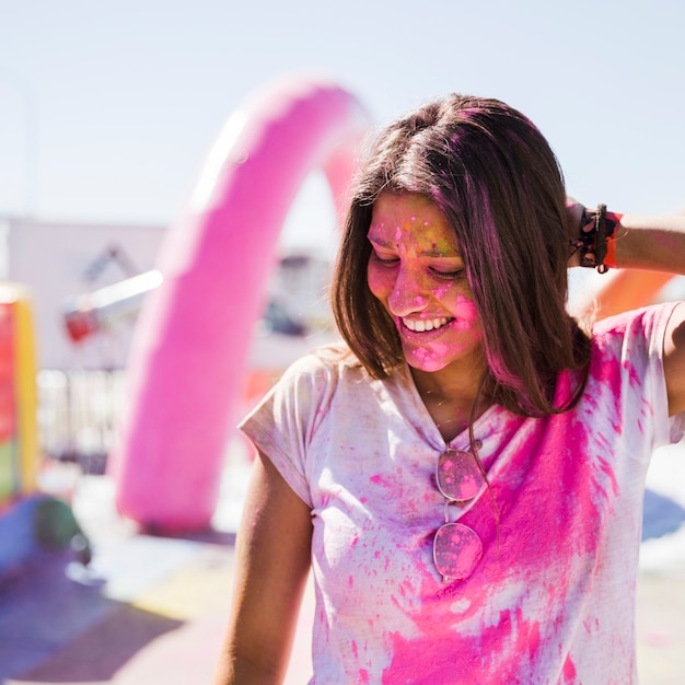 Retrato, de, um, sorrindo, mulher jovem, coberto, com, cor holi cor-de-rosa